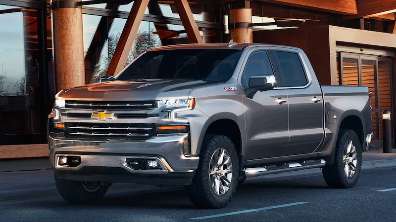 A 2019 Chevrolet Silverado parked in front of a modern building, showcasing its sleek design and robust presence.
